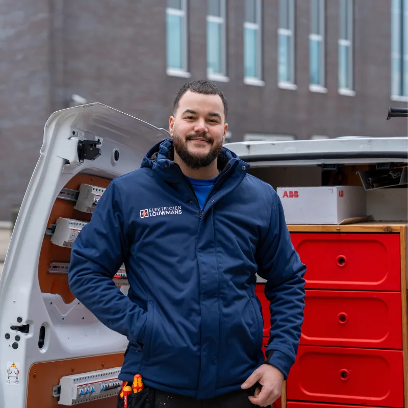Elektricien van Louwmans bij de geopende bedrijfsbus met materiaal